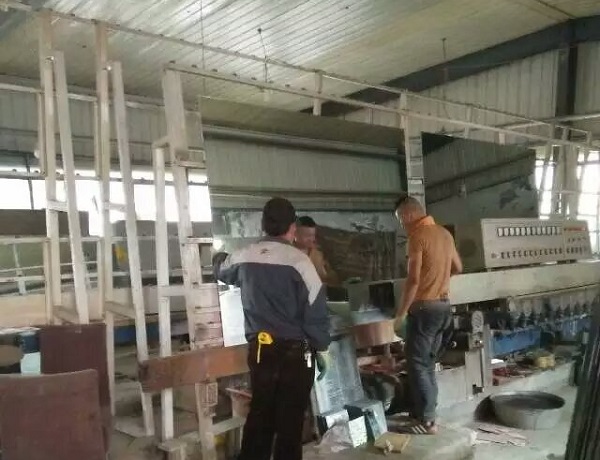 工人協作對玻璃進行打磨